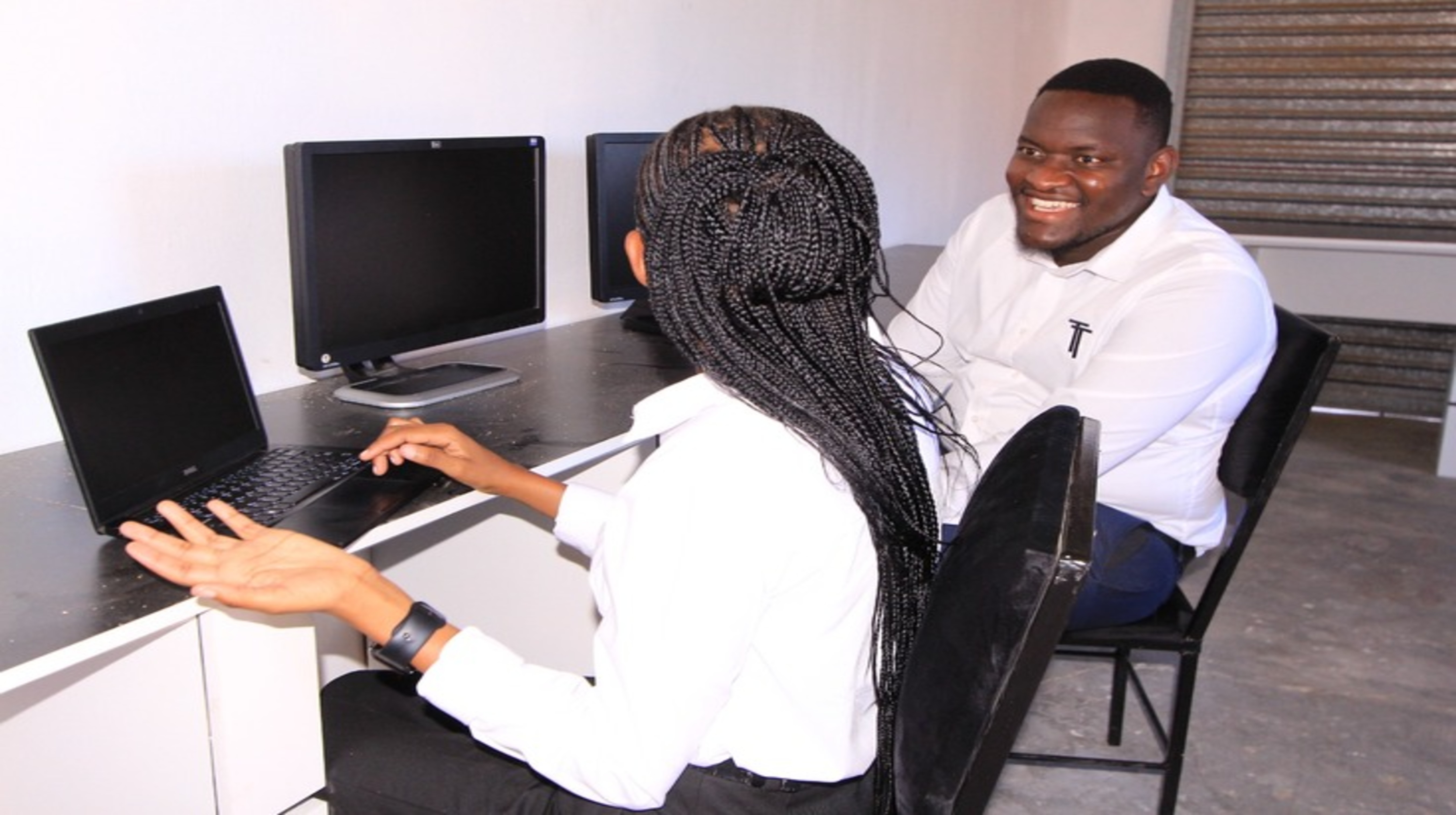 Two people working together at computers in the Tenebix learning space